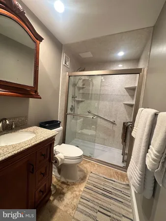 a bathroom with a granite countertop sink toilet and shower