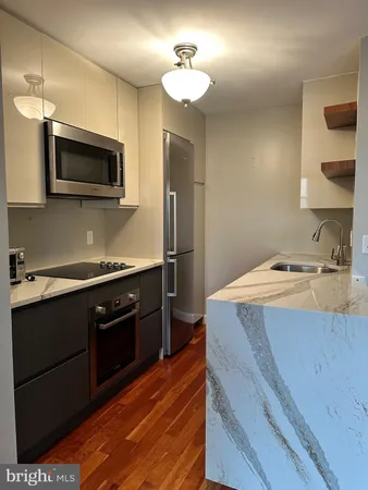 a kitchen with stainless steel appliances granite countertop a sink and a stove top oven