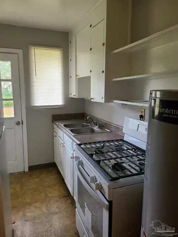 a kitchen with granite countertop a stove and a refrigerator