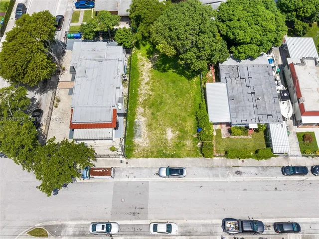an aerial view of residential houses with outdoor space and street view