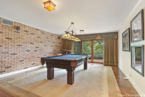 a dining room with stainless steel appliances granite countertop a sink a stove a dining table and chairs with wooden floor