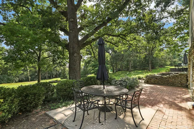 a view of a tennis ground with large trees
