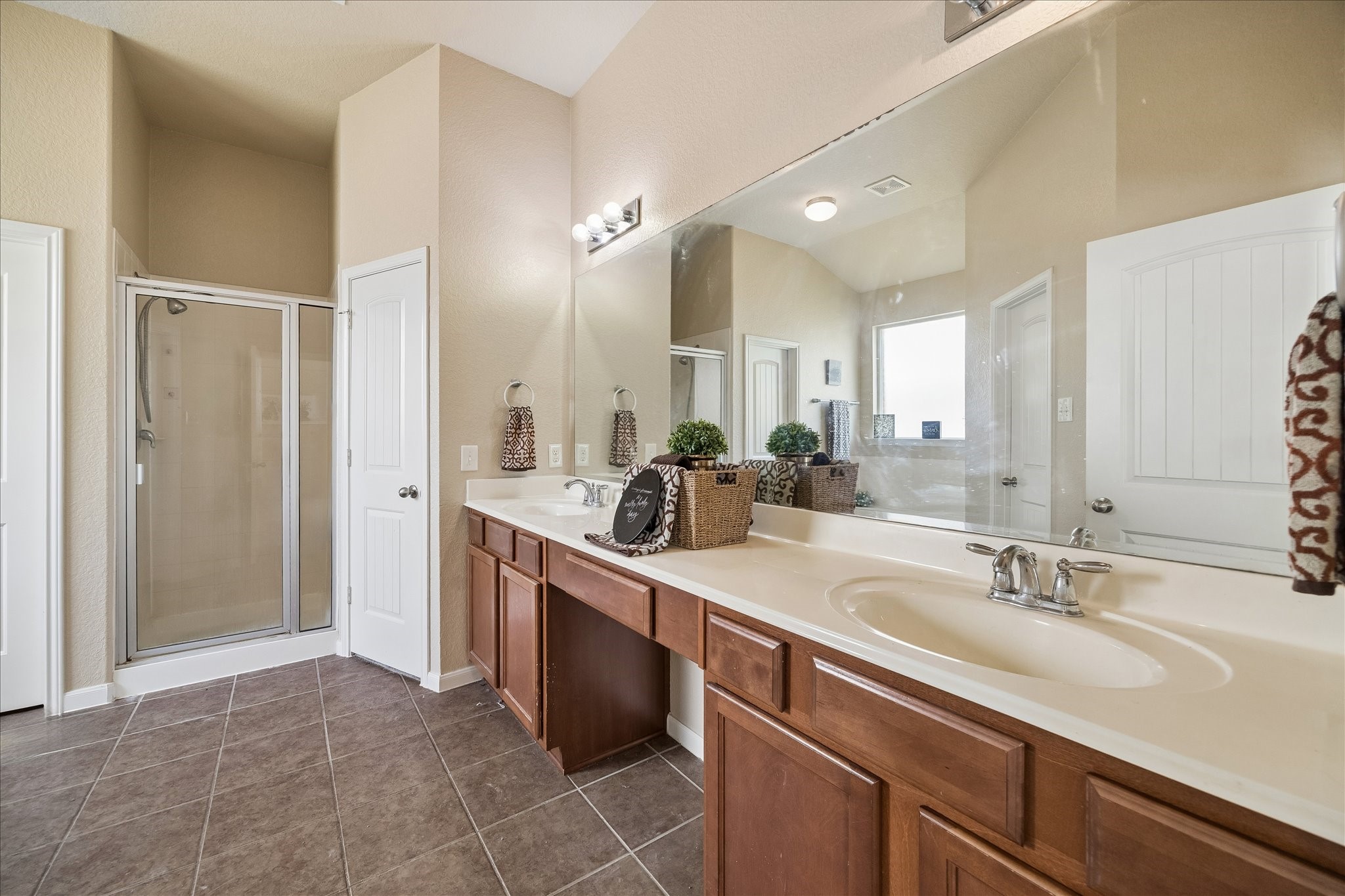 7806 Summer Night Lane Rosenberg, TX 77469 - Photo 15 of 23 The primary bathroom includes a double vanity with dark cabinetry, modern lighting, and a large mirror.