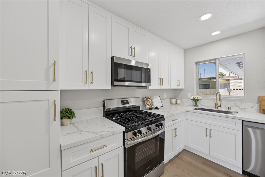 2484 Anglia Street Las Vegas, NV 89142 - Photo 5 of 20 This modern kitchen features crisp cabinetry, gleaming countertops, and modern appliances for seamless meal preparation.