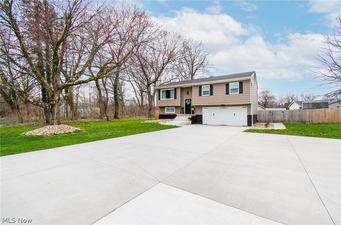 Raised ranch with a front yard and a garage