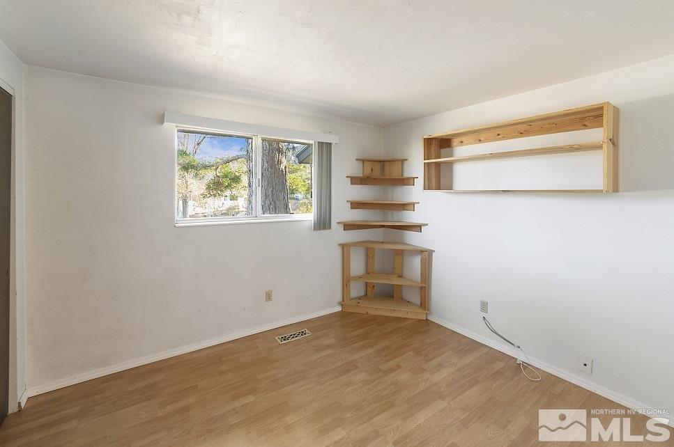 8780 Paloma Way Reno, NV 89506 - Photo 12 of 22 a view of empty room with a fireplace and wooden floor