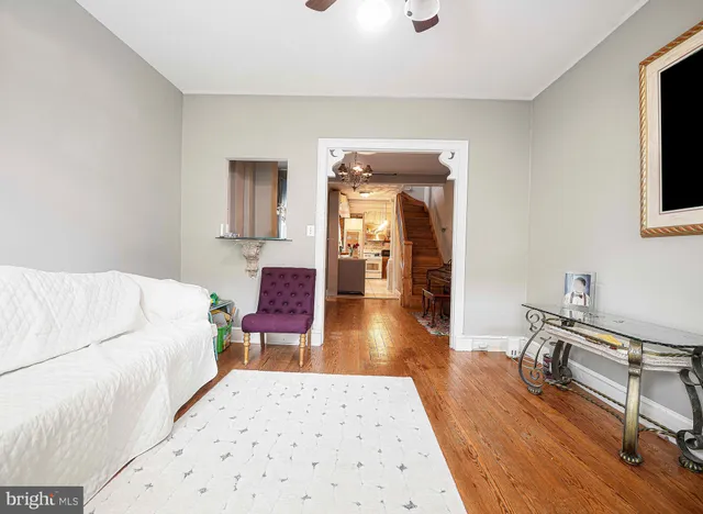 a living room with a bed furniture and a wooden floor