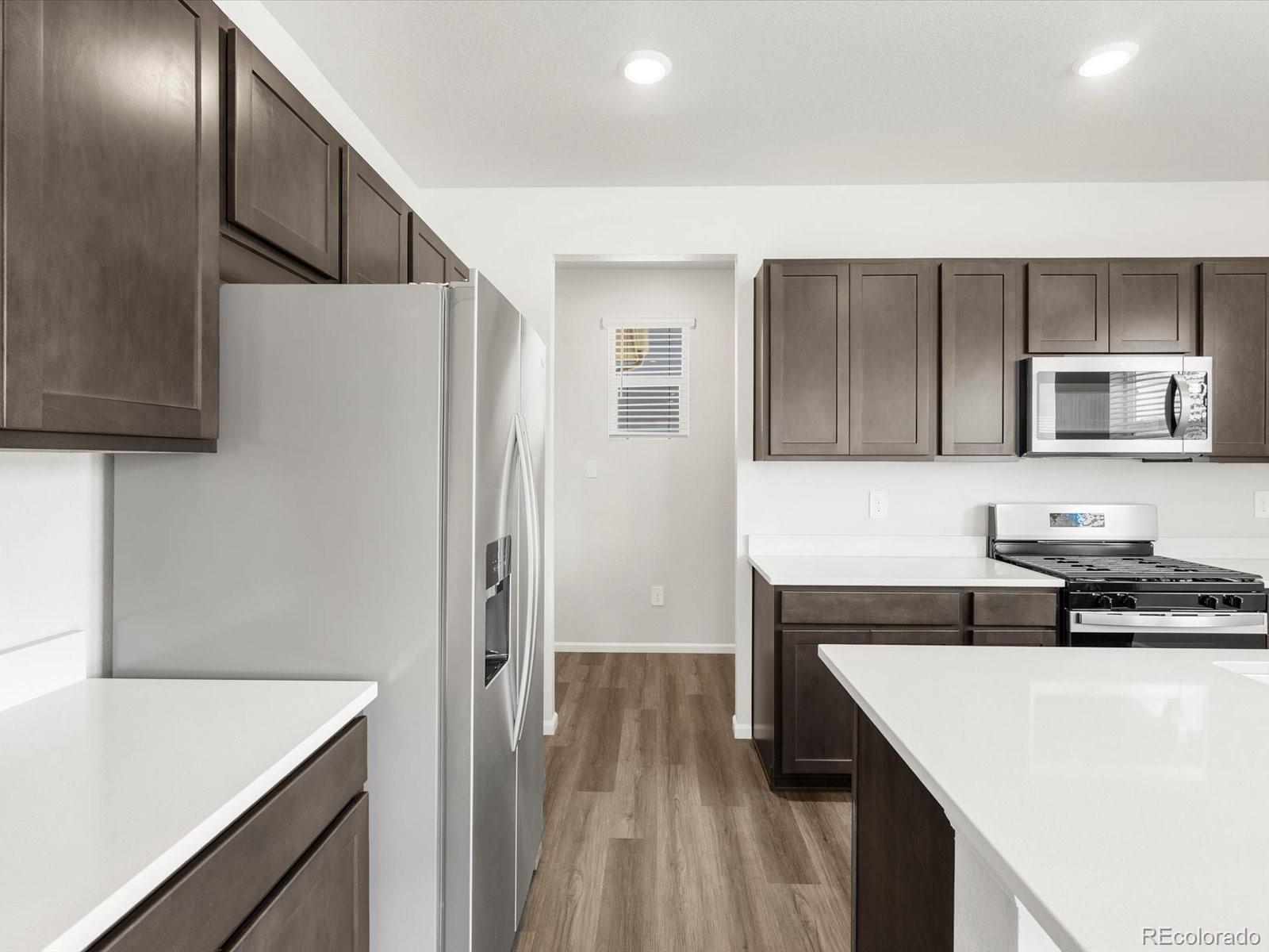 7300 West 27th St Road Greeley, CO 80634 - Photo 12 of 39 a kitchen with a sink a stove a refrigerator and cabinets