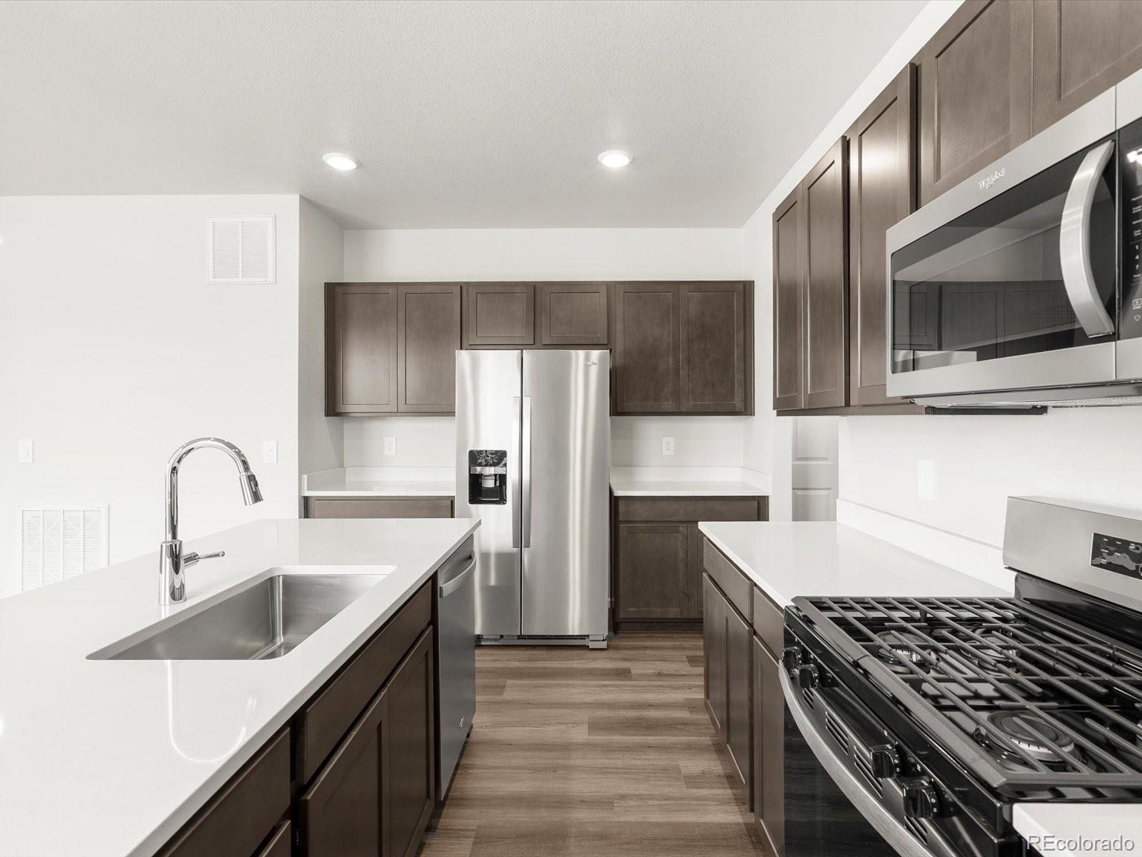 7300 West 27th St Road Greeley, CO 80634 - Photo 14 of 39 a kitchen with stainless steel appliances a sink stove and refrigerator