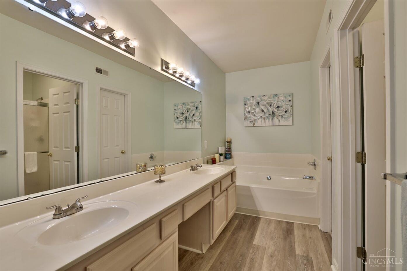 5315 Cooper Road, Unit G Montgomery, OH 45242 - Photo 20 of 35 Dual sinks, spacious vanity and soaking tub. The walk-in closet is the closed door reflected in the mirror, and the open door leads to the shower