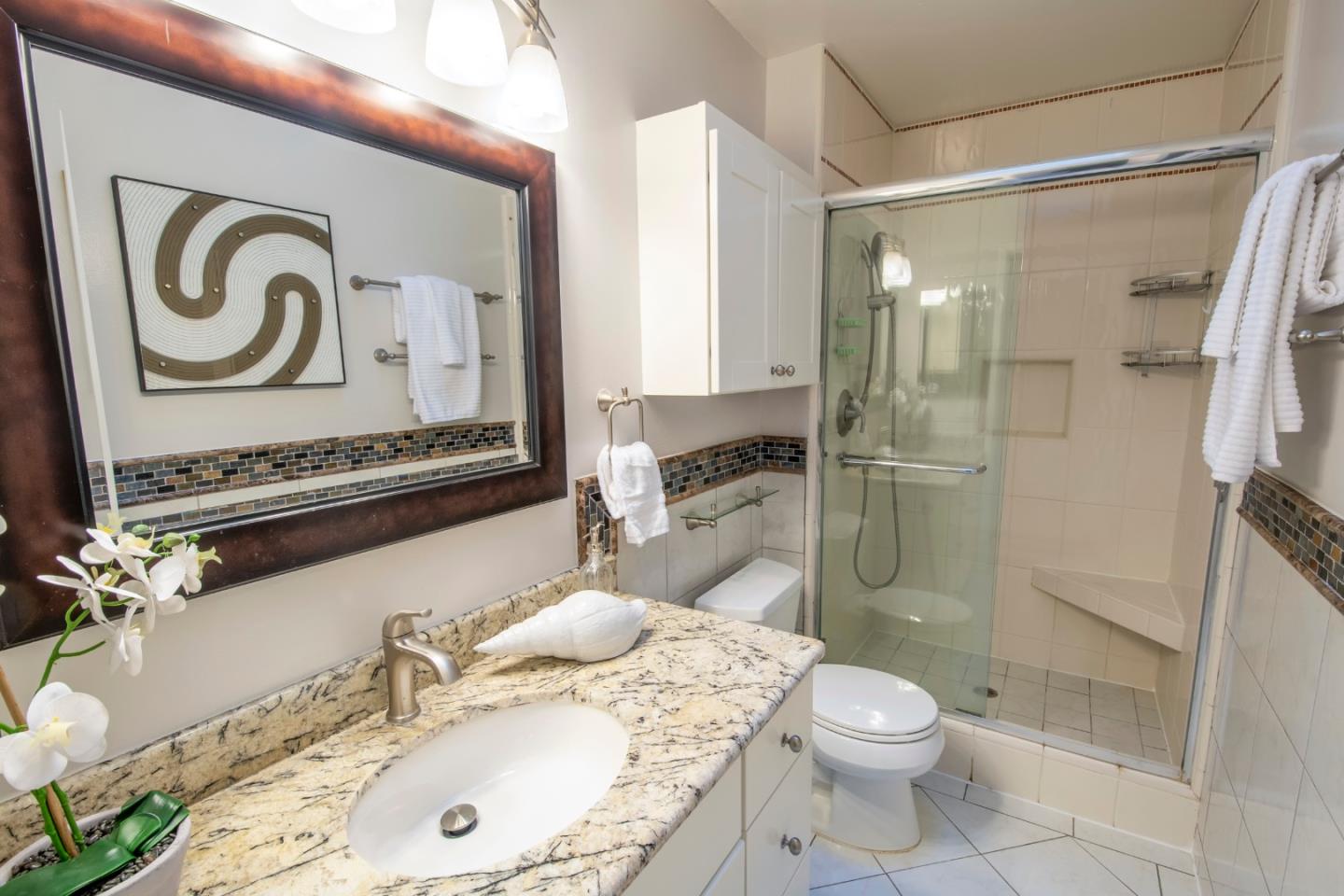 22991 Longdown Road Cupertino, CA 95014 - Photo 23 of 31 a bathroom with a granite countertop sink toilet and shower