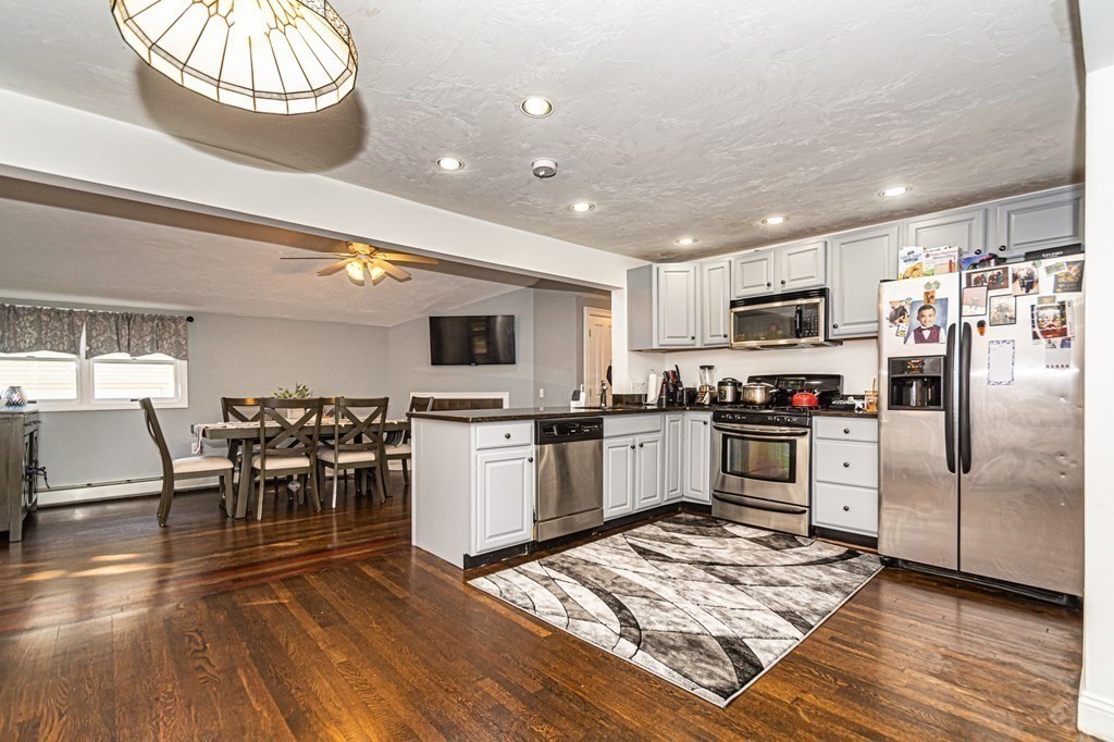a kitchen with granite countertop stainless steel appliances a refrigerator microwave and stove top oven