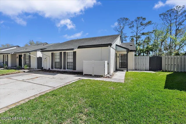 front view of a house with a yard and a garage