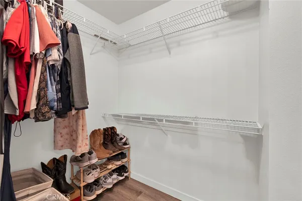 a view of walk in closet with clothes and shoes