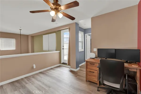 a view of workspace with wooden floor and ceiling fan