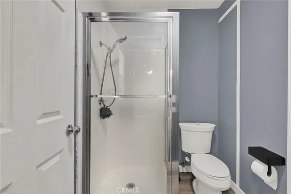 a white toilet sitting next to a shower