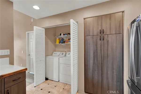 a walk in closet with wooden floor and a bathroom