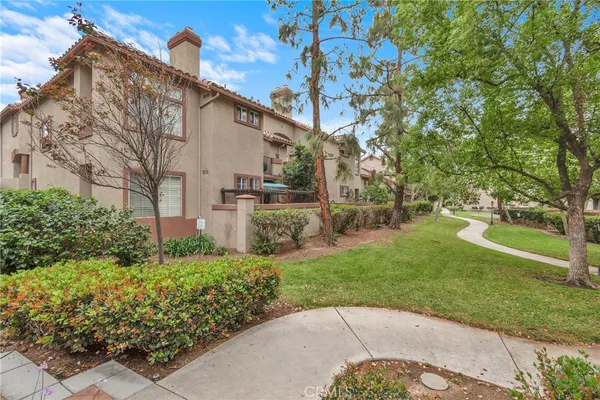 a view of a white house with a yard and potted plants