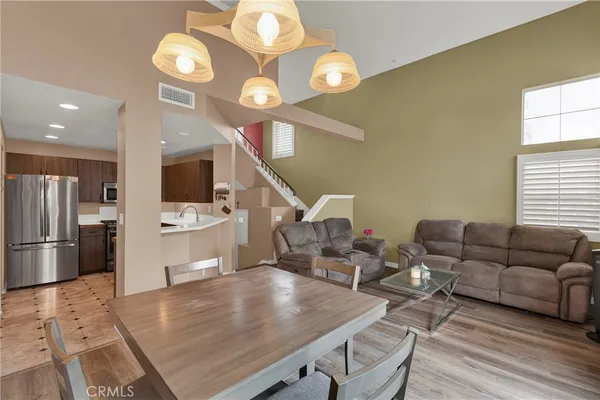 a living room with furniture kitchen view and a large window