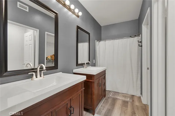 a bathroom with double vanity sinks and a mirror