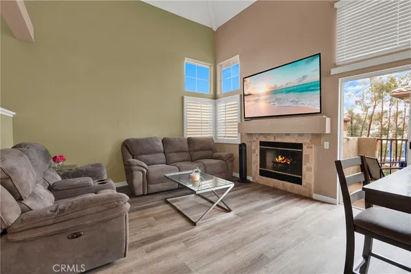 a living room with furniture a flat screen tv and a fireplace