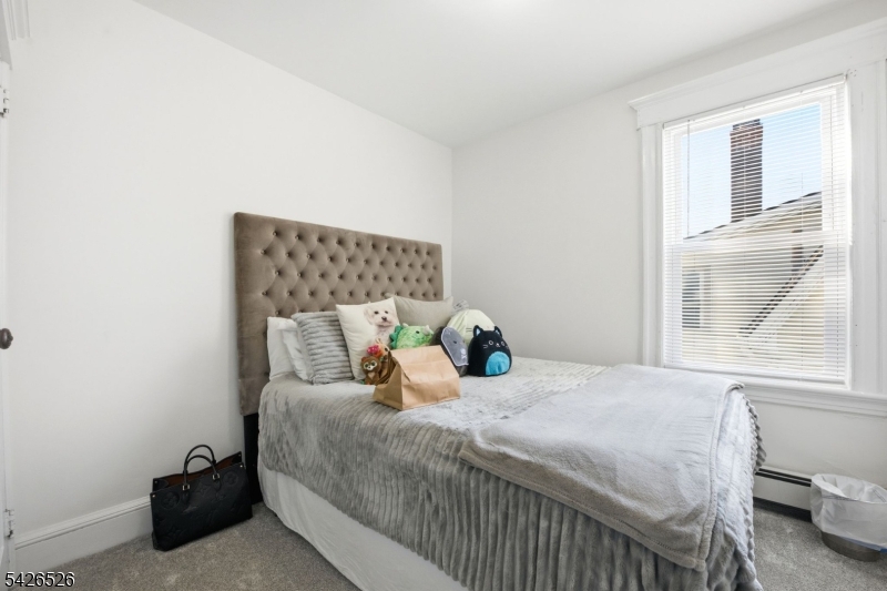 39 Wilmore Road, Unit 2 Little Falls, NJ 07424 - Photo 8 of 14 a bed sitting in a bedroom next to a window
