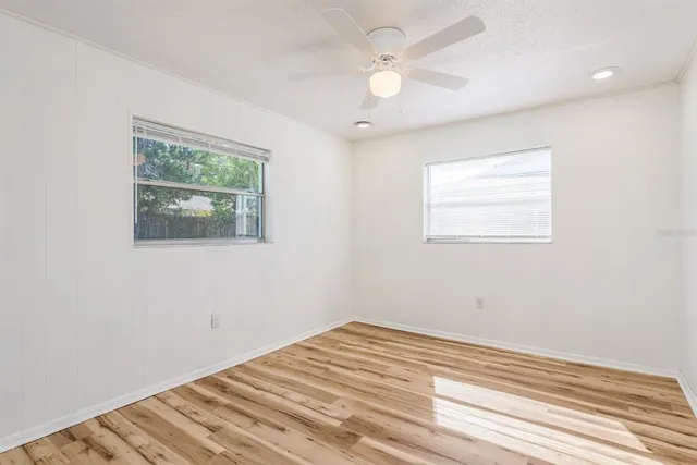 a view of a livingroom with wooden floor and a ceiling fan