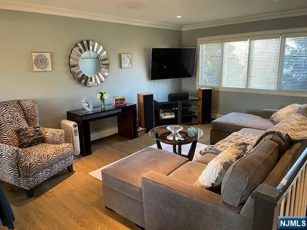a living room with furniture a flat screen tv and a large window