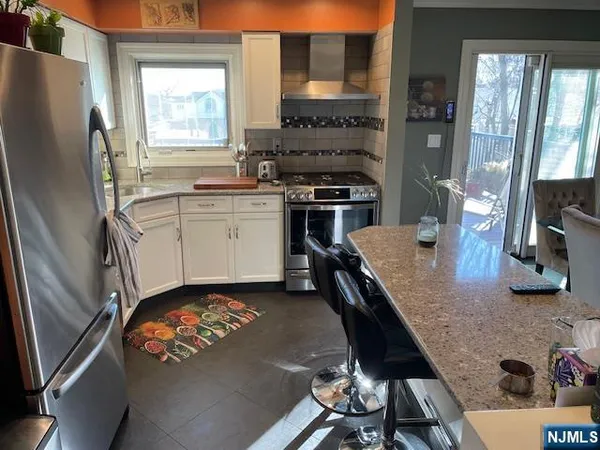 a kitchen with granite countertop a refrigerator stove and sink