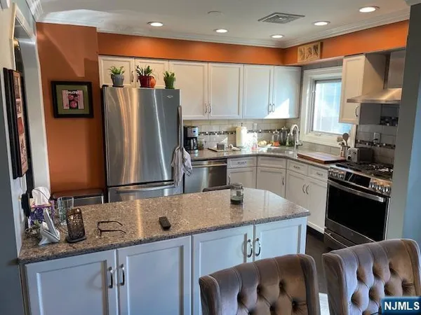 a kitchen with stainless steel appliances a sink stove and refrigerator
