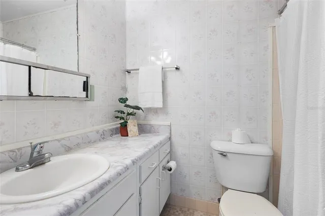 a bathroom with a granite countertop toilet sink and mirror