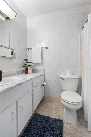 a bathroom with a granite countertop toilet and sink