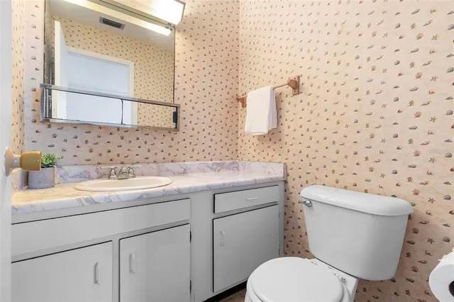 a bathroom with a granite countertop toilet sink and mirror