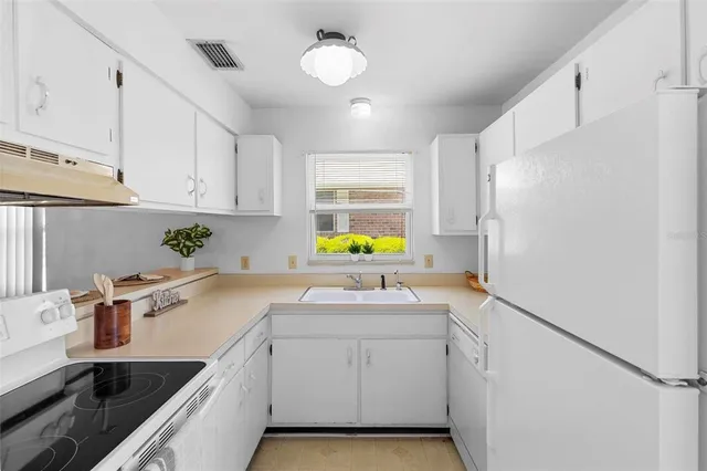 a kitchen with a sink cabinets and window