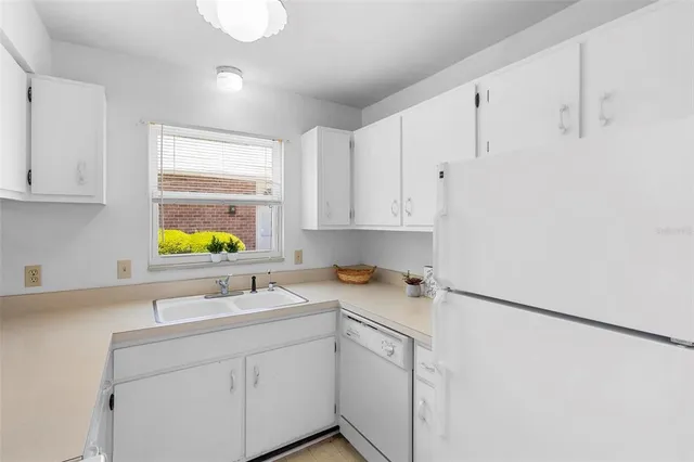 a kitchen with stainless steel appliances white cabinets and a sink