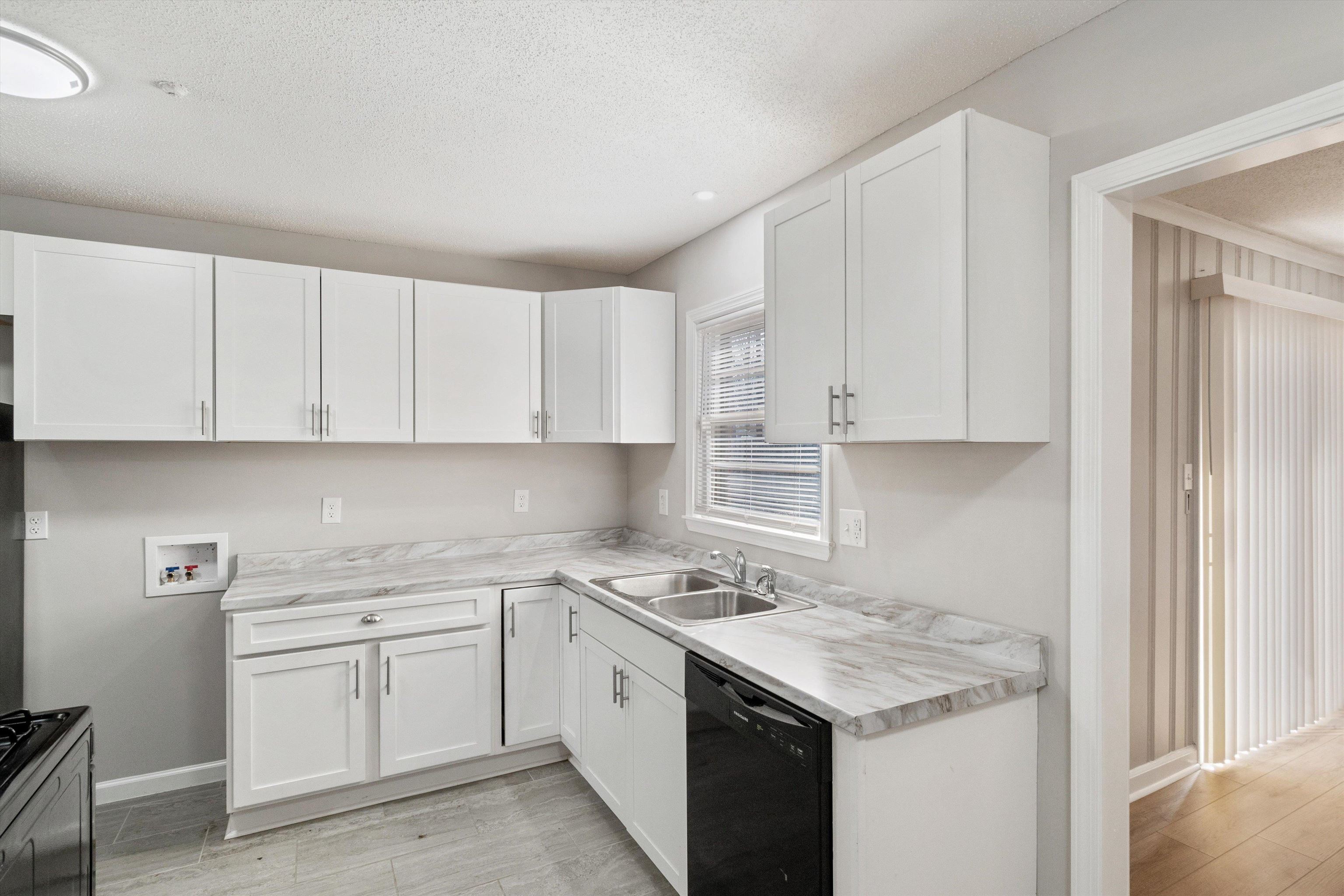4487 East Dearing Road Memphis, TN 38117 - Photo 11 of 27 Kitchen with light countertops, black dishwasher, white cabinets, a textured ceiling, and gas range oven