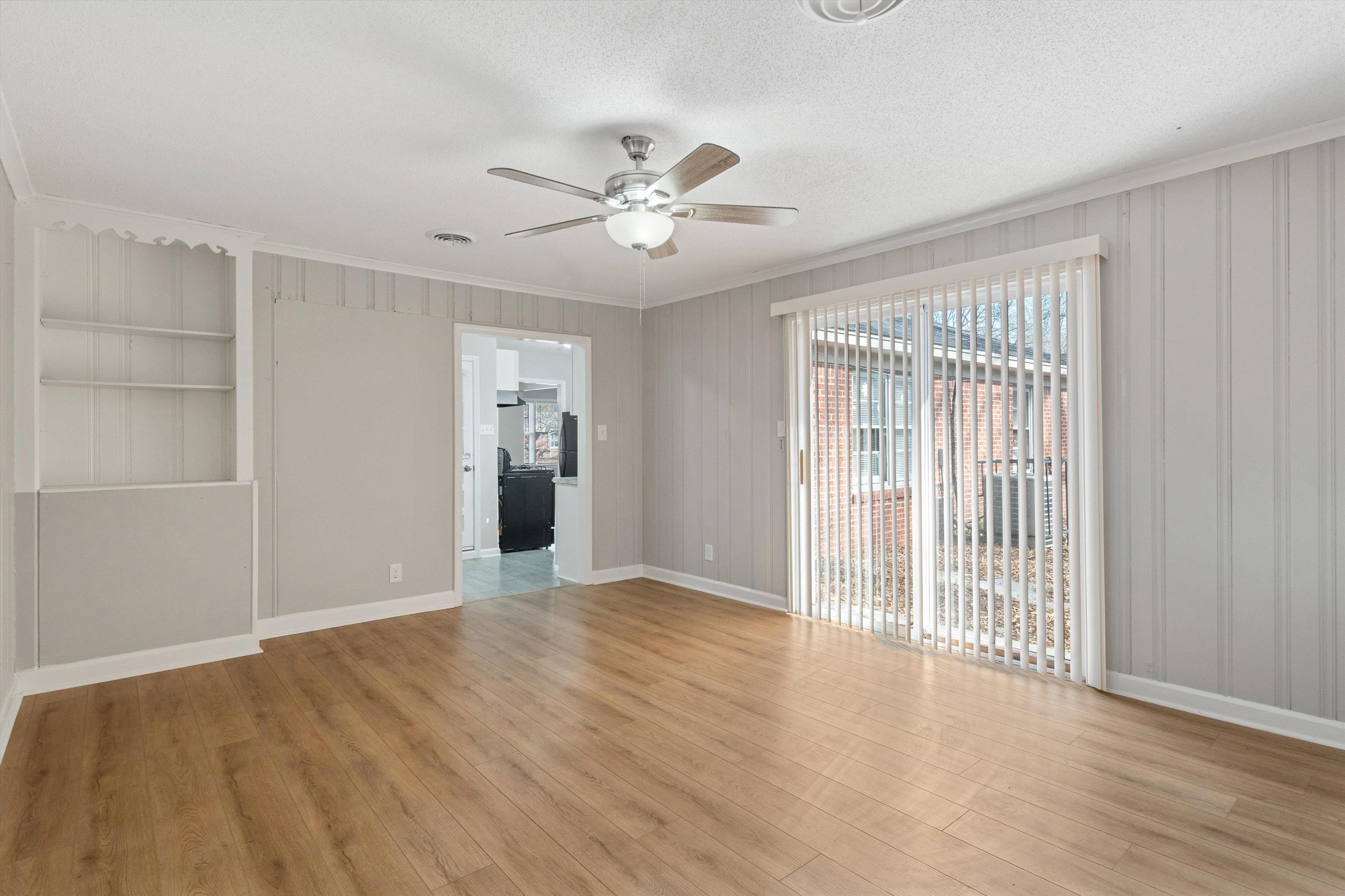 4487 East Dearing Road Memphis, TN 38117 - Photo 13 of 27 Unfurnished room with crown molding, light wood-style flooring, built in features, a textured ceiling, and a ceiling fan
