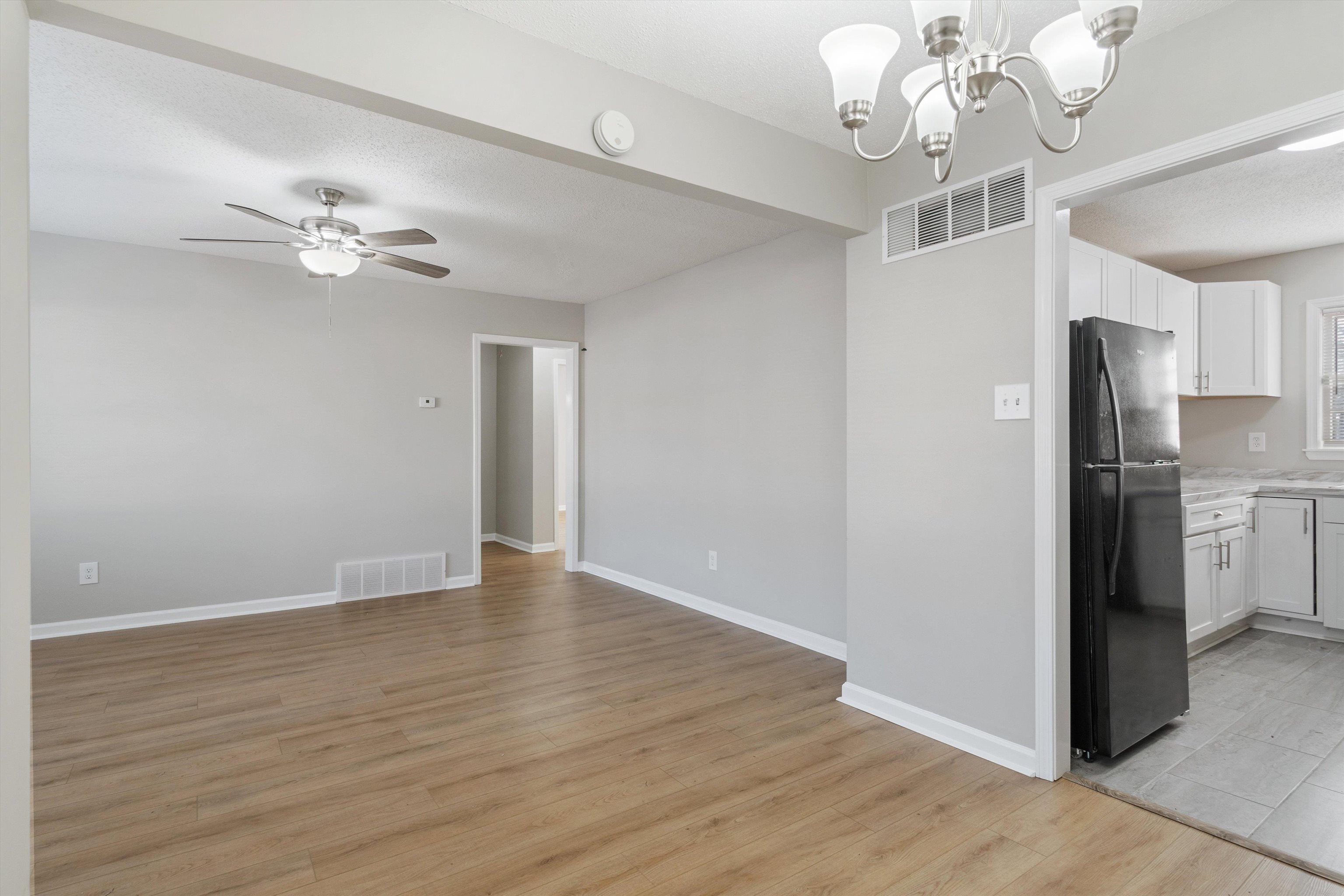 4487 East Dearing Road Memphis, TN 38117 - Photo 8 of 27 Unfurnished dining area with light wood-style floors, ceiling fan, a chandelier, and a textured ceiling