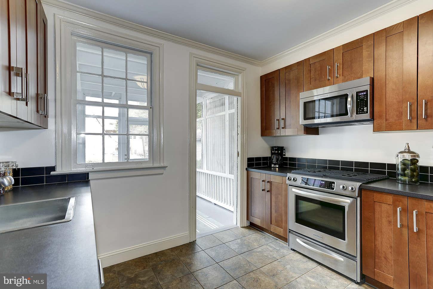 3707 Reservoir Road Northwest Washington, DC 20007 - Photo 8 of 19 a kitchen with granite countertop a stove top oven microwave and cabinets