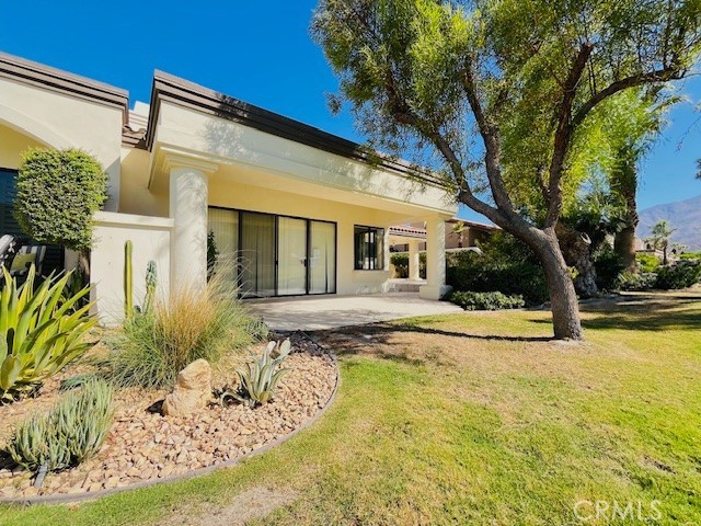 a view of white house with large windows and a tree