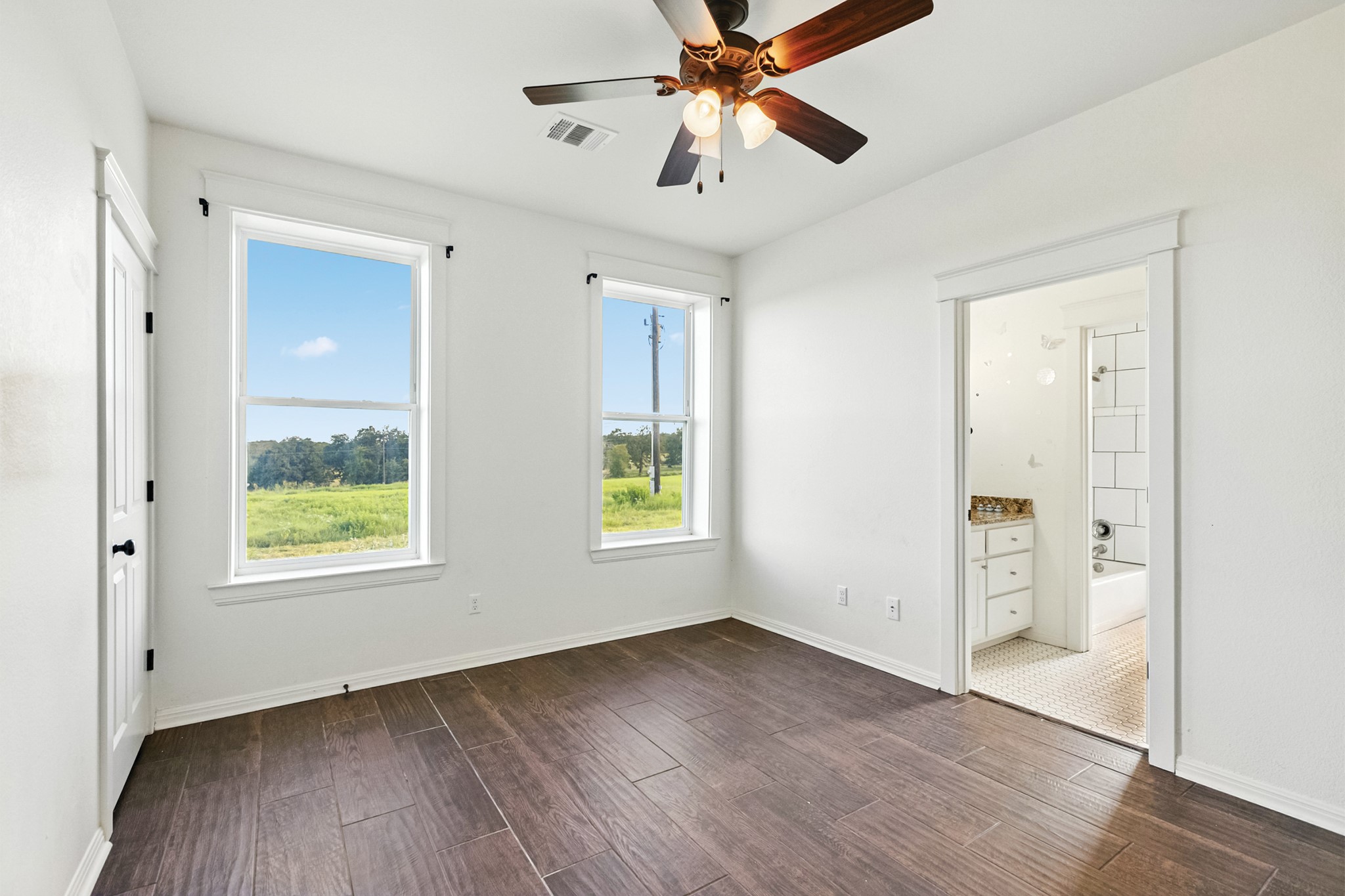 498 North County Line Road Elgin, TX 78621 - Photo 40 of 40 Unfurnished bedroom featuring dark wood-type flooring, ensuite bathroom, and a ceiling fan