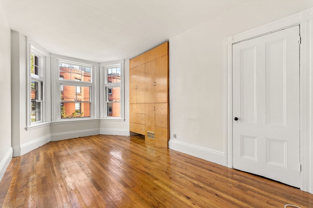 18 Symphony Road Boston, MA 02115 - Photo 18 of 34 a view of an empty room with wooden floor and a window