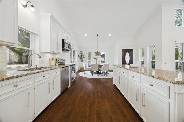 a large kitchen with stainless steel appliances lots of counter space and wooden floor