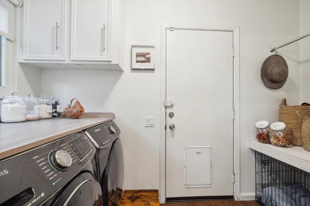 a view of cabinets and utility room with wooden floor