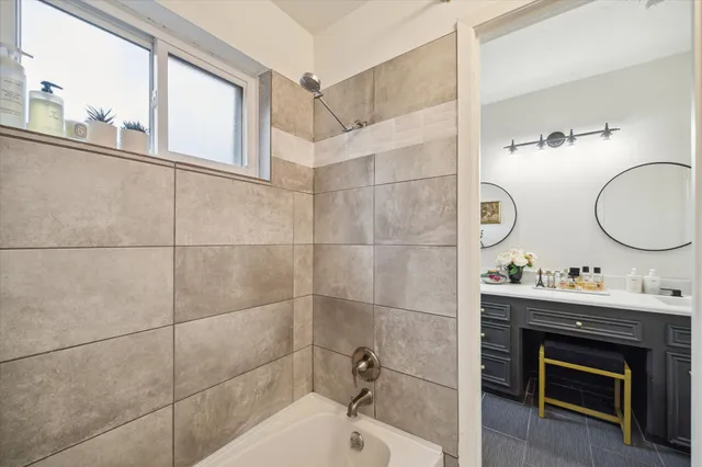 a bathroom with a sink mirror and a bathtub
