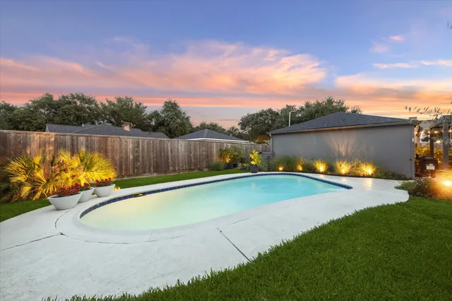 a view of a swimming pool with a yard and sitting area