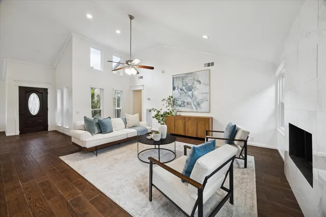 a living room with furniture a fireplace and a chandelier