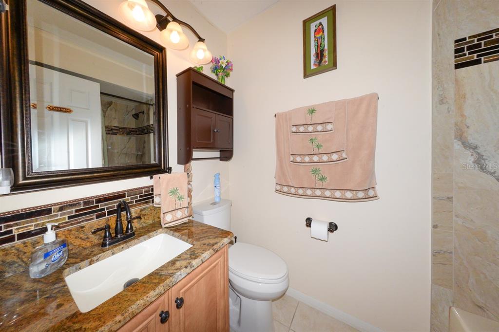 335 Coldeway Drive, Unit F21 Punta Gorda, FL 33950 - Photo 21 of 45 a bathroom with a granite countertop toilet sink and mirror