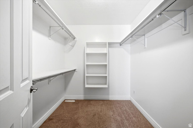 1089 West 2325th Street North Layton, UT 84041 - Photo 20 of 40 Walk-in closet featuring built-in shelving, two hanging rods, a wire basket, and plush carpet flooring