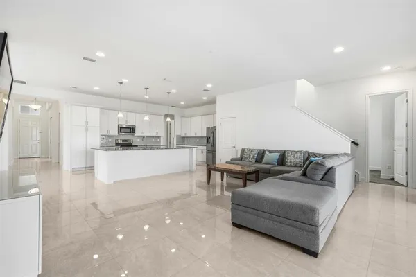 a large kitchen with stainless steel appliances kitchen island granite countertop a refrigerator and a sink